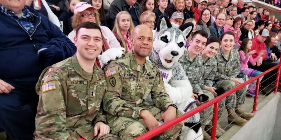 The Color Guard team takes a photo with the UConn mascot